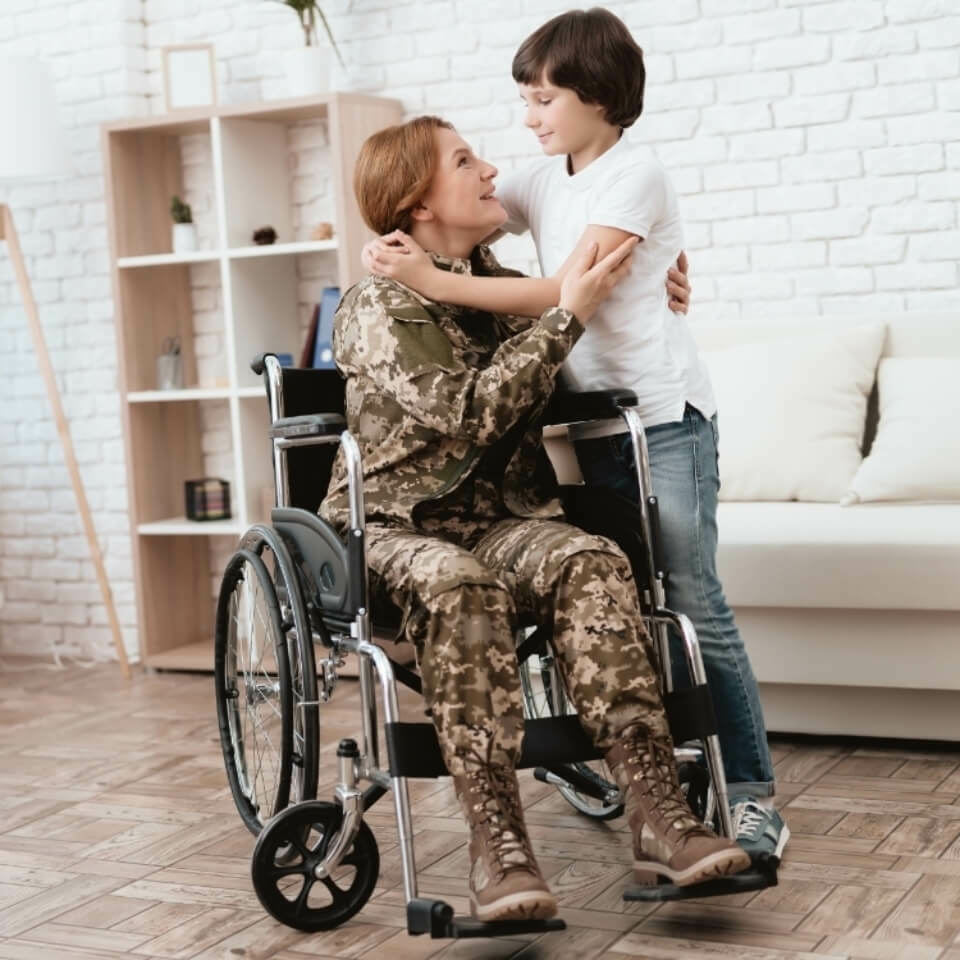 Uniformed female veteran in a wheelchair hugging a child.