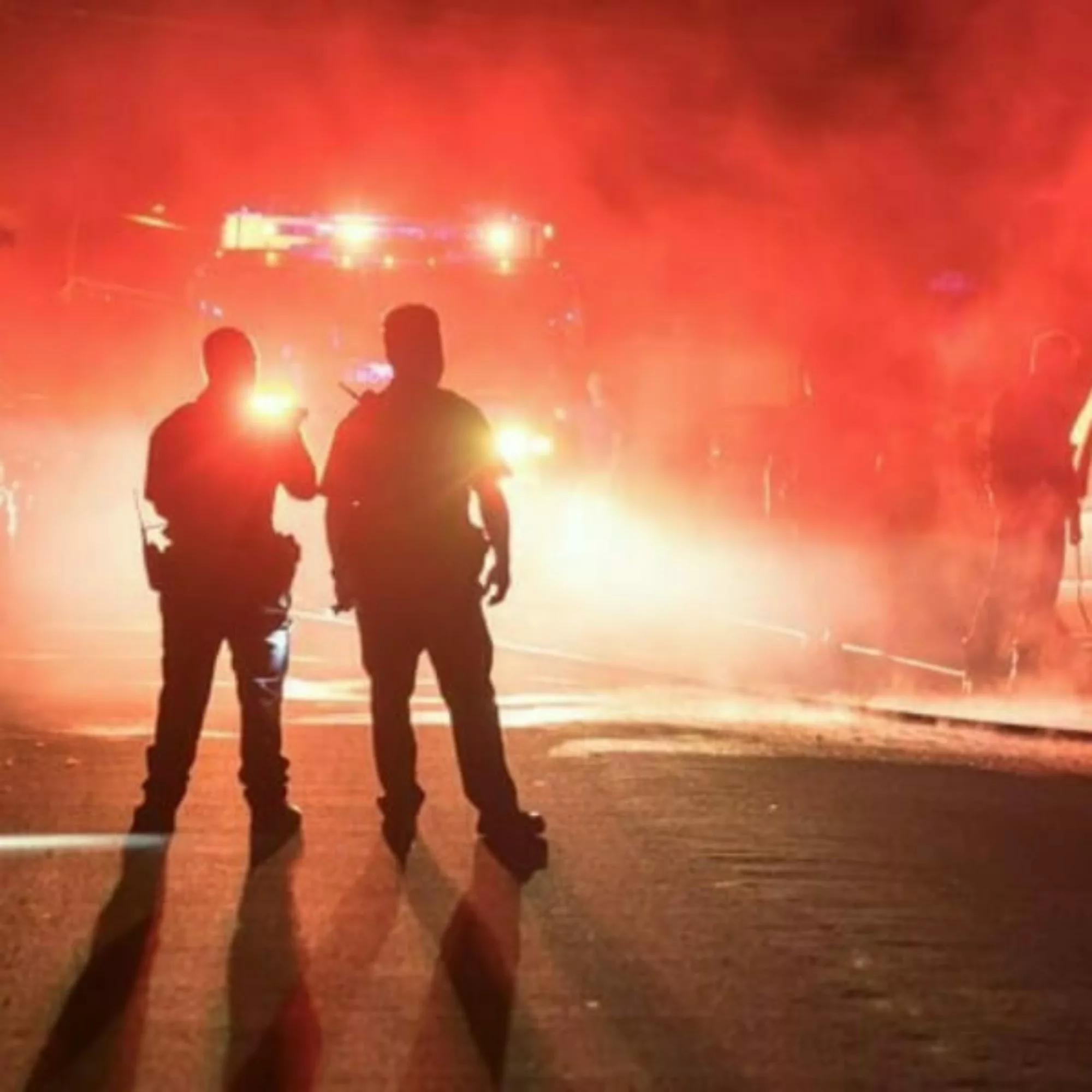 Silhouettes of first responders in warning lights.