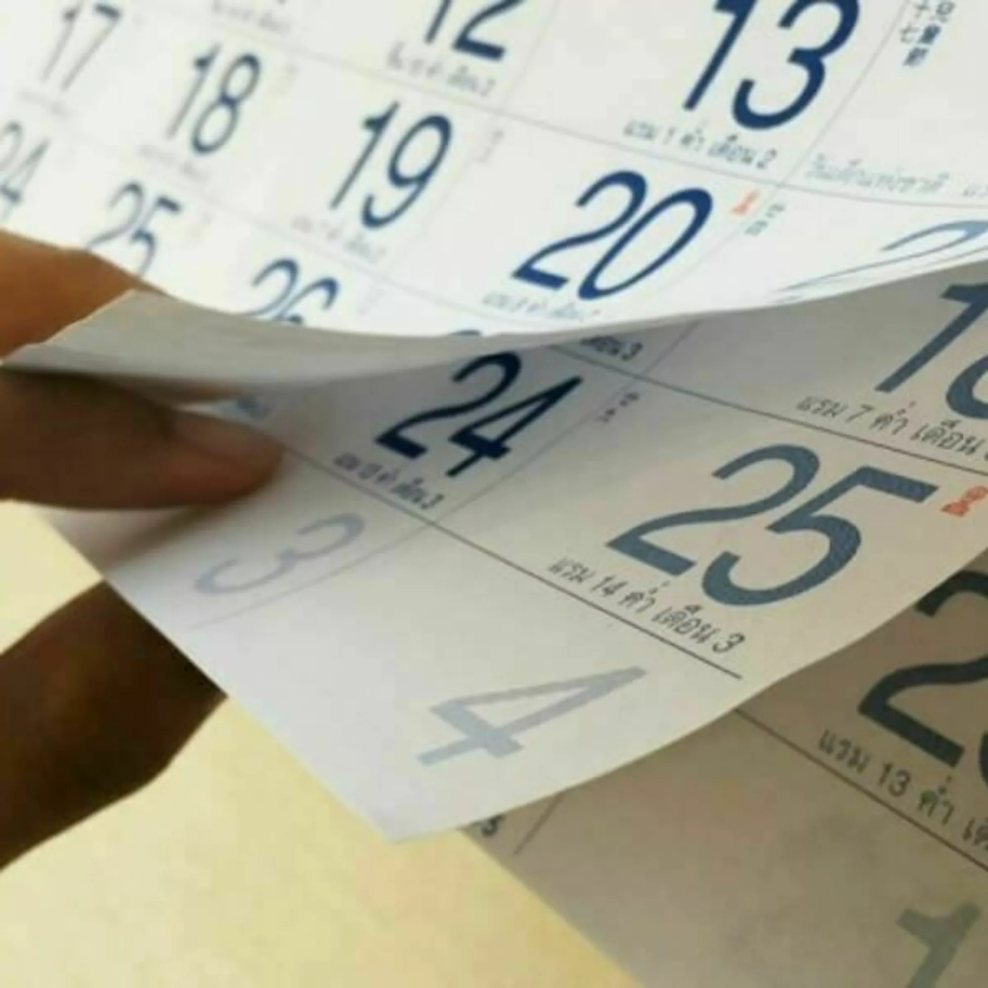 Hand flipping through a calendar.