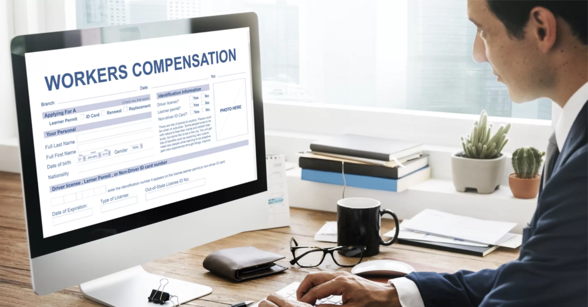 Man at a computer looking at Workers' Compensation form.