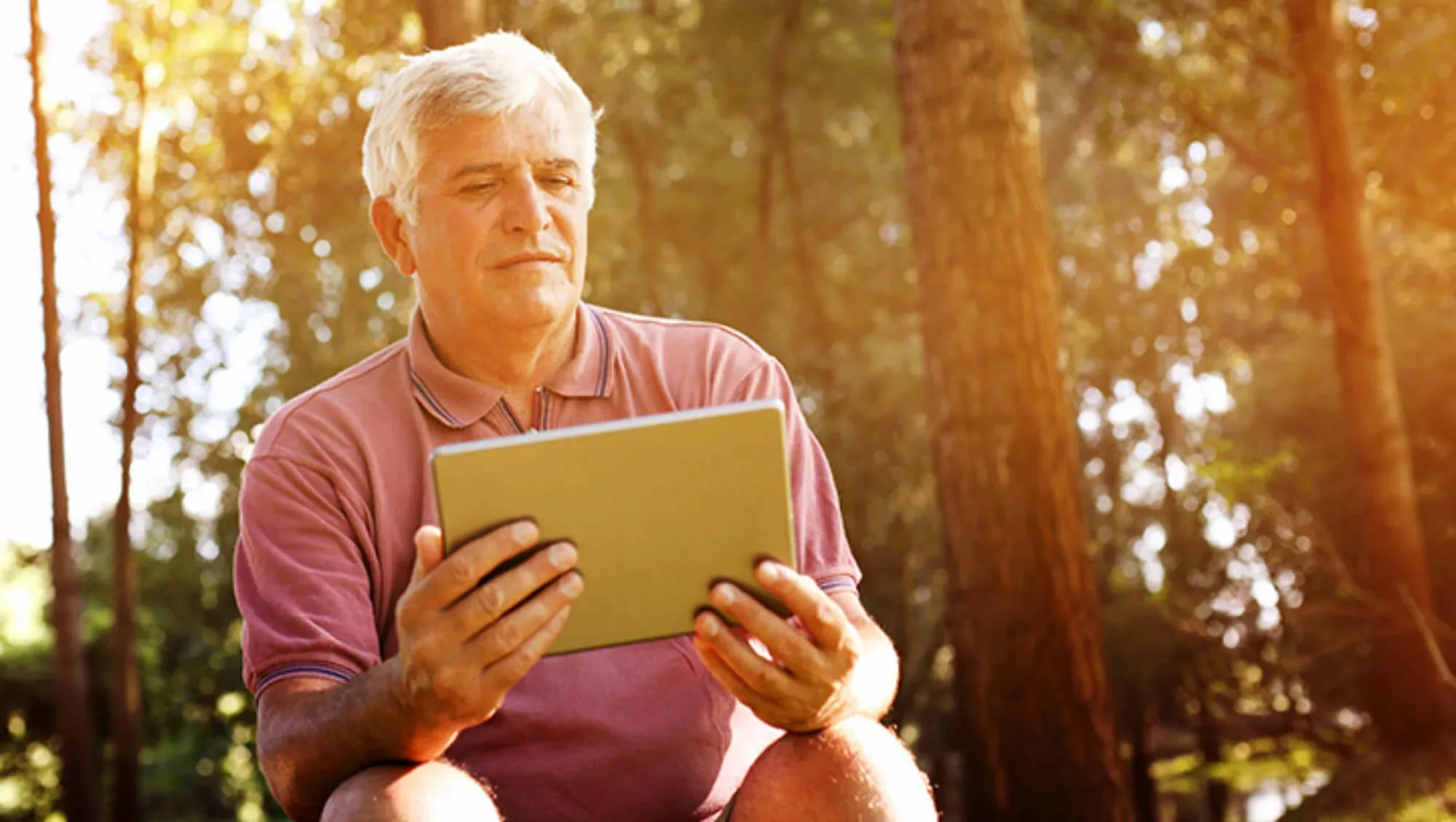 Man sitting looking at a tablet.