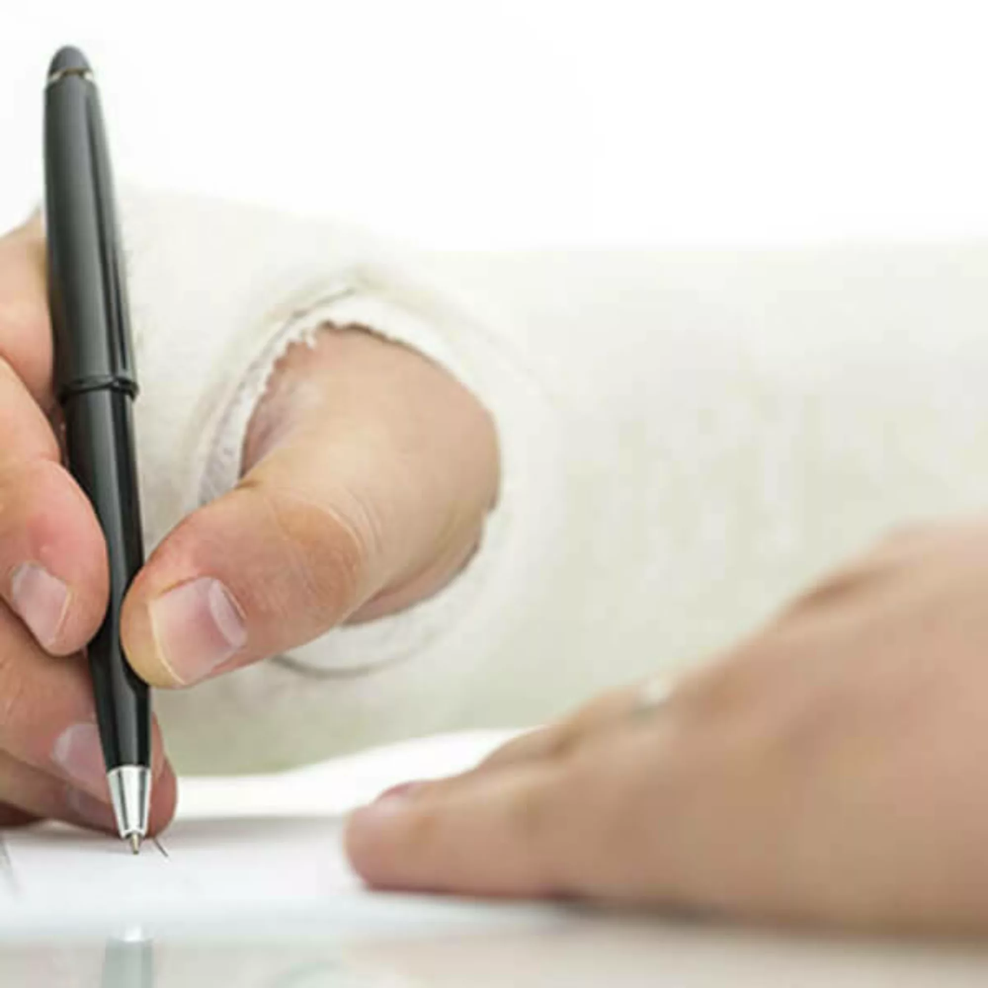 Close up of hand in a cast writing.