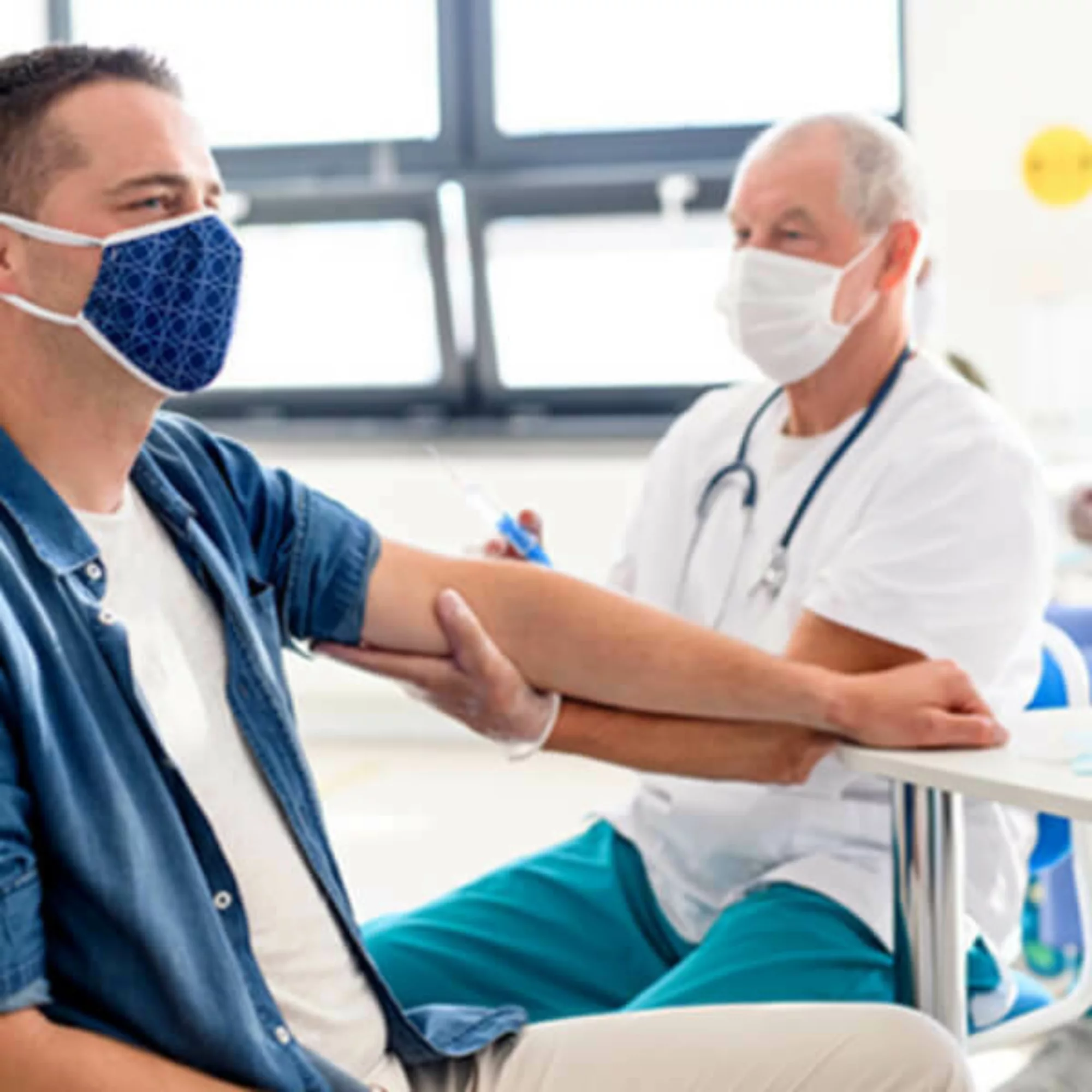 Doctor assessing arm of a patient.