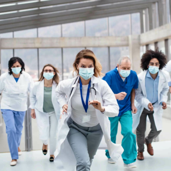 Five hospital workers in masks running.