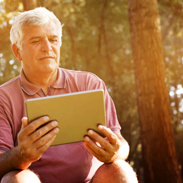 Man sitting looking at a tablet.
