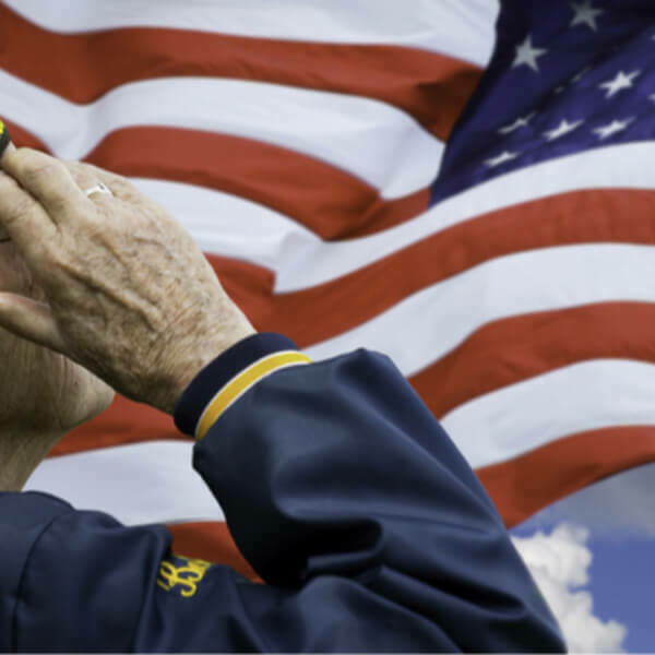 Older veteran saluting the American flag.
