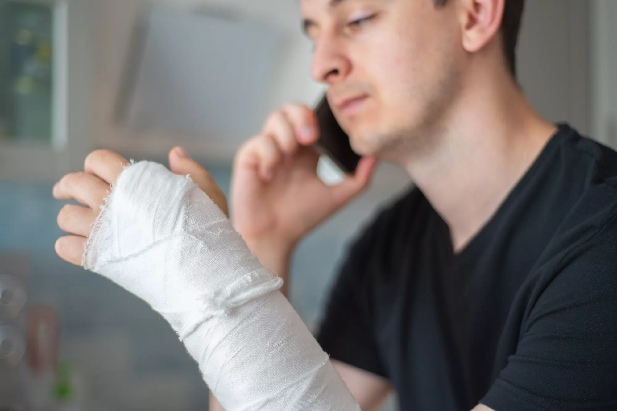 Man with wrist cast on the phone.