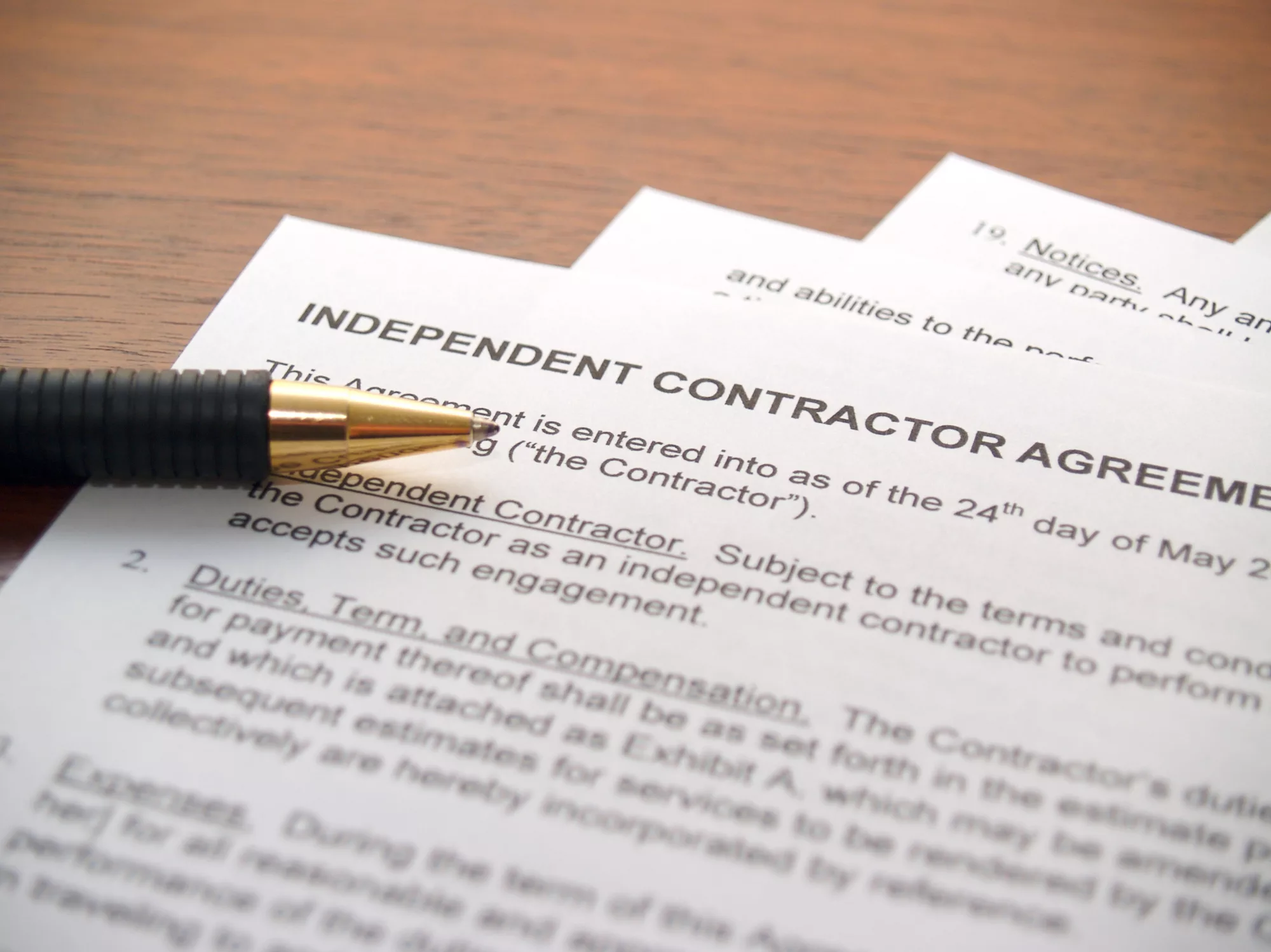 Close up of independent contractor agreement with pen.